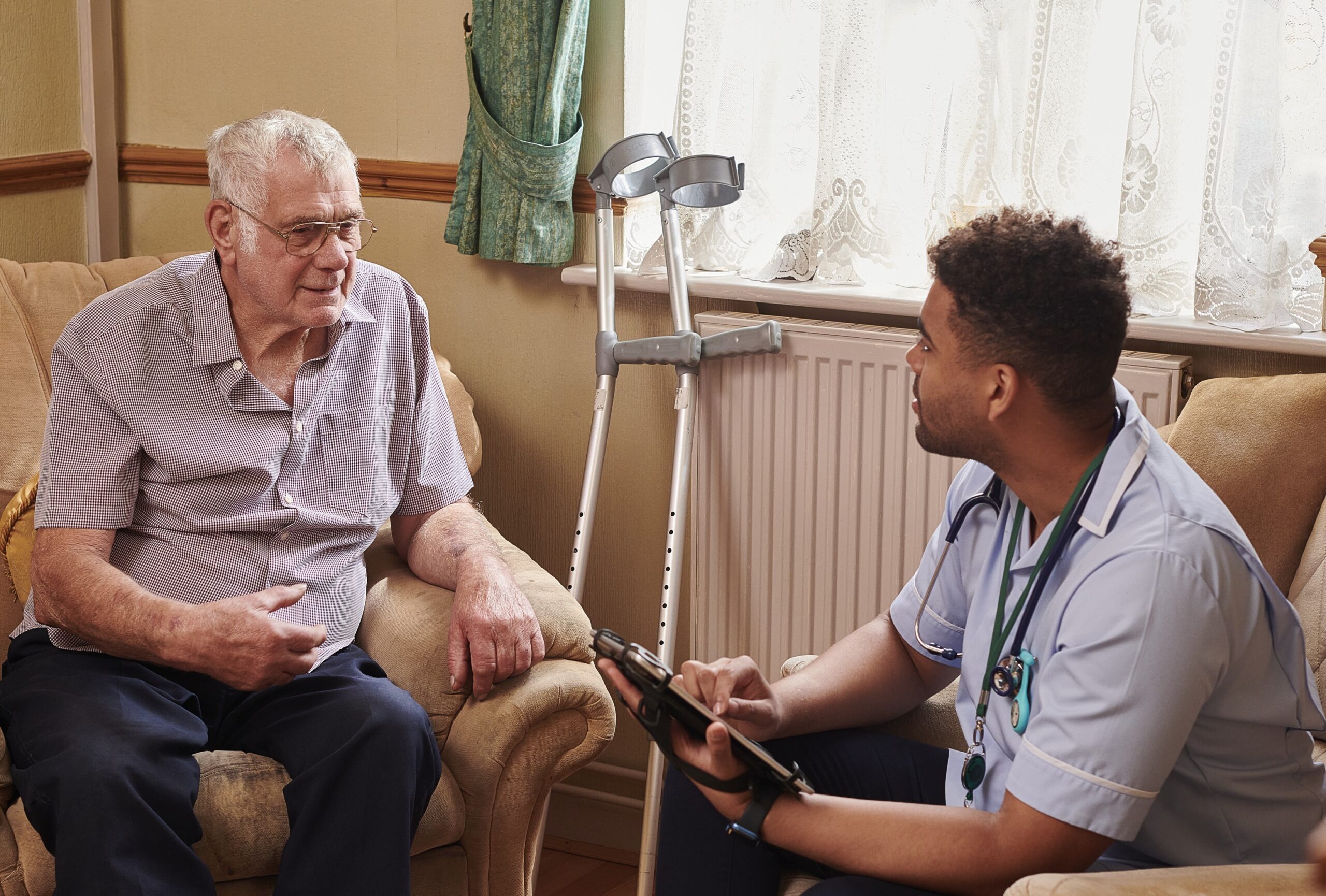 adult social care nurse with tech to assist patient with crutches