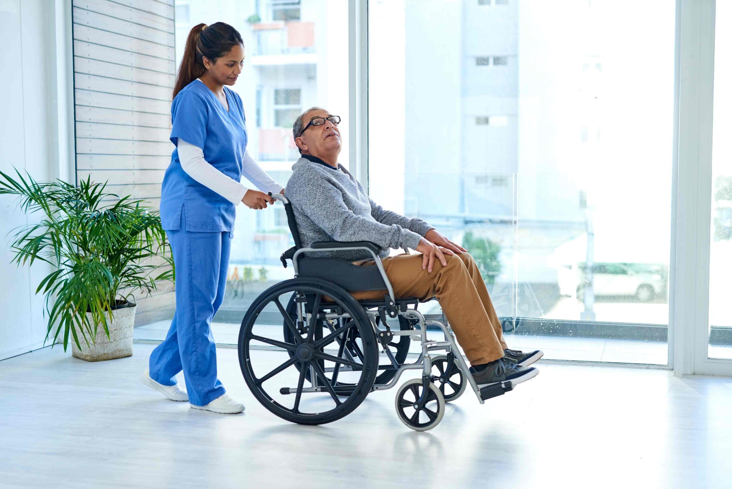Nurse pushing a man in a wheelchair